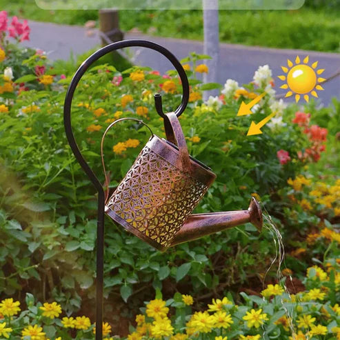 Regadera solar en un cantero de flores